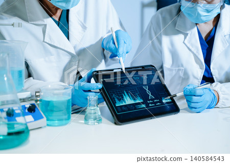 Scientists analyzing DNA genetics data on tablet in biotechnology laboratory with microscope and test tubes. Medical research, healthcare technology 140584543