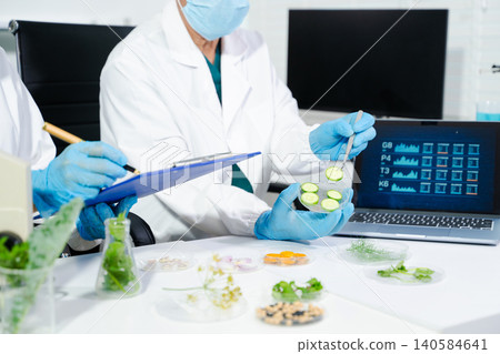 Two Asian scientists in a lab conducting food research using a microscope and lab equipment, showcasing innovation in food science and biotechnology Two Asian scientists in a lab conducting food research using a microscope and lab equipment, showcasing innovation in food science and biotechnology 140584641