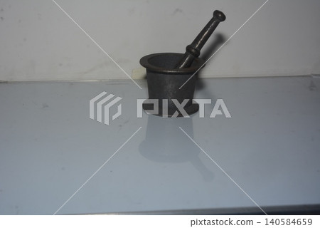 Small dark metallic mortar and pestle for grinding herbs and spices 140584659