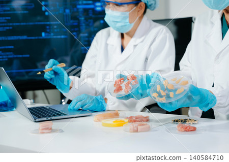 Scientists developing lab grown meat in food science laboratory. Biotechnology research on sustainable protein, alternative agriculture and future food Scientists developing lab grown meat in food science laboratory. Biotechnology research on sustainable protein, alternative agriculture and future food 140584710