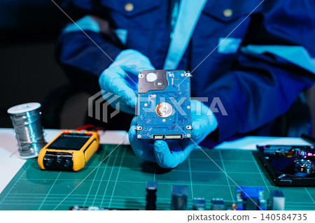 Technician repairing inside of hard disk drive by screwdriver. the concept of data, hardware, technician and technology. computer hardware, repairing, upgrade Technician repairing inside of hard disk drive by screwdriver. the concept of data, hardware, technician and technology. computer hardware, repairing, upgrade 140584735