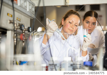 Confident women technicians working in research laboratory Confident women technicians working in research laboratory 140584775