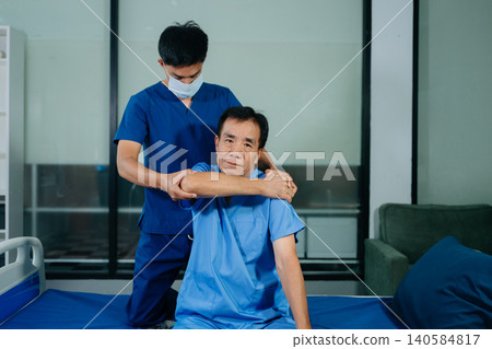 Physiotherapist assisting senior patient with shoulder rehabilitation in hospital clinic. Healthcare, recovery, pain relief and elderly mobility Physiotherapist assisting senior patient with shoulder rehabilitation in hospital clinic. Healthcare, recovery, pain relief and elderly mobility 140584817
