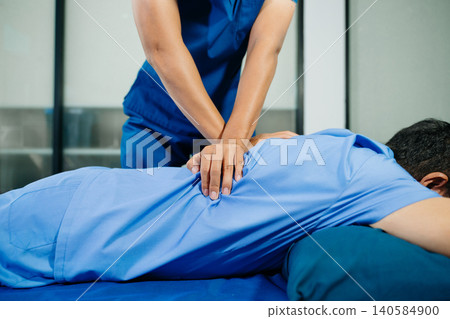 Physiotherapist performing manual chest therapy on patient in rehabilitation clinic. Healthcare treatment, physiotherapy massage, injury recovery Physiotherapist performing manual chest therapy on patient in rehabilitation clinic. Healthcare treatment, physiotherapy massage, injury recovery 140584900
