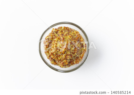 白色背景上的小碟子裡盛著顆粒狀芥末醬。 白色背景上的小碟子裡盛著顆粒狀芥末醬。 140585214