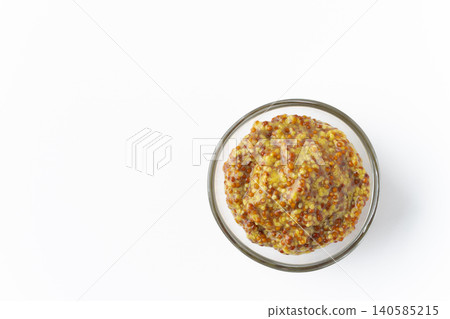 Grainy mustard in a small dish against a white background. 140585215