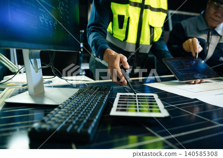 Engineers analyzing solar panels and wind turbine model with digital energy data. Concept of renewable energy, sustainable technology, green power innovation 140585308