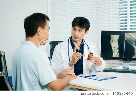 Doctor explaining bone and joint condition to patient in clinic. Orthopedic care, diagnosis, injury treatment Doctor explaining bone and joint condition to patient in clinic. Orthopedic care, diagnosis, injury treatment 140585440