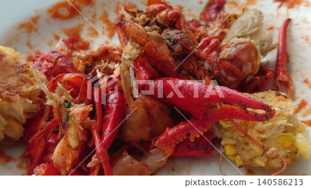 Crayfish shells and leftovers left on a white plate after the meal. 140586213