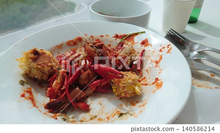 Leftover crayfish dish and an empty plate on a cafe table. Leftover crayfish dish and an empty plate on a cafe table. 140586214