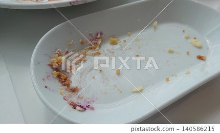 The meal is finished, and only breadcrumbs and sauce remain on the clean white plate. 140586215