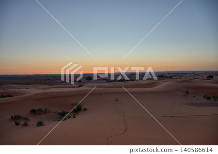 A stunning desert landscape reveals undulating textures in the twilight light of Merzouga, Morocco. A stunning desert landscape reveals undulating textures in the twilight light of Merzouga, Morocco. 140586614