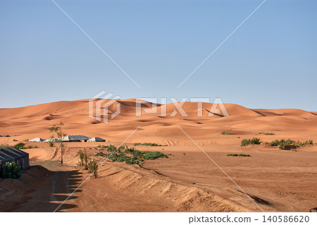 A stunning desert landscape reveals undulating textures in the twilight light of Merzouga, Morocco. A stunning desert landscape reveals undulating textures in the twilight light of Merzouga, Morocco. 140586620
