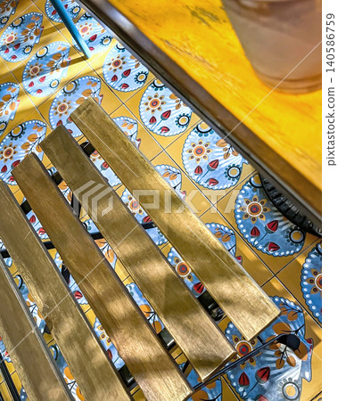 Sunlight streams onto a wooden bench over decorative tiles in a cafe Sunlight streams onto a wooden bench over decorative tiles in a cafe 140586759