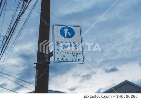 Pedestrian-only road sign with time restrictions in a residential area at dusk. Pedestrian-only road sign with time restrictions in a residential area at dusk. 140586866