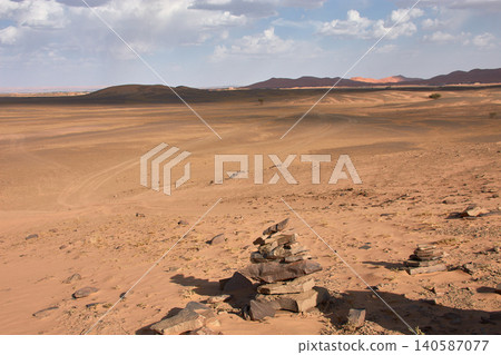 A small pebble tower rises against the vast Saharan landscape in Merzouga, Morocco A small pebble tower rises against the vast Saharan landscape in Merzouga, Morocco 140587077