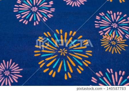 A Japanese-style fabric with a vibrant fireworks pattern on an indigo background. A Japanese-style fabric with a vibrant fireworks pattern on an indigo background. 140587783