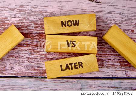 Blocks are arranged on a wooden surface with the words Now and Later to represent choices in time management. This setup highlights decision making Blocks are arranged on a wooden surface with the words Now and Later to represent choices in time management. This setup highlights decision making 140588702