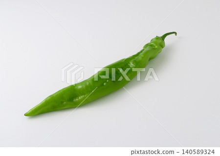 A green horn pepper, a vegetable with long, horn-shaped leaves, against a white background. A green horn pepper, a vegetable with long, horn-shaped leaves, against a white background. 140589324