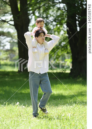 A young father walking with his daughter on his shoulders. A young father walking with his daughter on his shoulders. 140589748