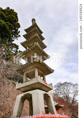 The small stone 5 story pagoda and stone lantern background with The 2-story pagoda at Katsuo-ji Temple in Minoh, Osaka, Japan. Temple of Daruma Dolls. The small stone 5 story pagoda and stone lantern background with The 2-story pagoda at Katsuo-ji Temple in Minoh, Osaka, Japan. Temple of Daruma Dolls. 140589824