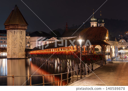 The illuminated Chapel Bridge over the Reuss River and the night view of Wasserturm. Lucerne, Lucerne Canton, Switzerland The illuminated Chapel Bridge over the Reuss River and the night view of Wasserturm. Lucerne, Lucerne Canton, Switzerland 140589878