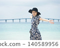 A woman wearing a straw hat at Yonaha Maehama Beach 140589956