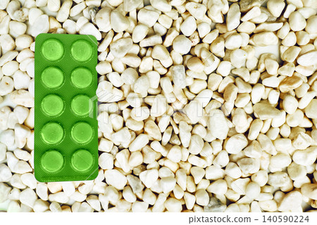 Taking medicine.Green pills tablets in blisters on white stones Taking medicine.Green pills tablets in blisters on white stones 140590224