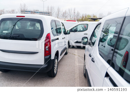 White delivery vans are parked in rows. Commercial fleet of vehicles White delivery vans are parked in rows. Commercial fleet of vehicles 140591193
