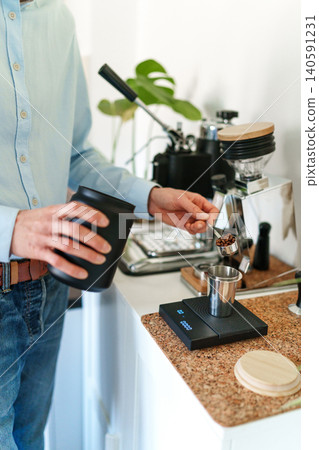 Man brewing espresso at home using a manual lever coffee machine. Man brewing espresso at home using a manual lever coffee machine. 140591231