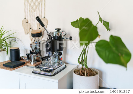 Home barista corner with a manual lever espresso machine and a single dose coffee grinder. Home barista corner with a manual lever espresso machine and a single dose coffee grinder. 140591237
