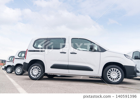 White delivery vans are parked in rows. Commercial fleet of vehicles. 140591396
