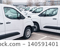 White delivery vans are parked in rows. Commercial fleet of vehicles 140591401