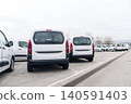 White delivery vans are parked in rows. Commercial fleet of vehicles.. 140591403