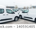 White delivery vans are parked in rows. Commercial fleet of vehicles 140591405