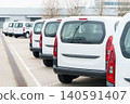 White delivery vans are parked in rows. Commercial fleet of vehicles 140591407