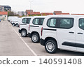 White delivery vans are parked in rows. Commercial fleet of vehicles. 140591408