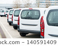 White delivery vans are parked in rows. Commercial fleet of vehicles. 140591409