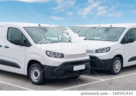 White delivery vans are parked in rows. Commercial fleet of vehicles White delivery vans are parked in rows. Commercial fleet of vehicles 140591414
