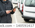 Fleet manager with digital tablet supervising rows of white delivery vans.. 140591417