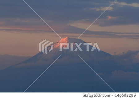 富士山頂峰沐浴在緋紅色的夕陽中,景色美不勝收。 富士山頂峰沐浴在緋紅色的夕陽中,景色美不勝收。 140592299