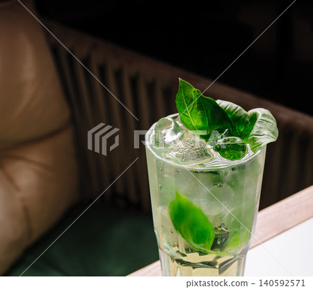 Green herbal cocktail with ice and basil leaves Green herbal cocktail with ice and basil leaves 140592571