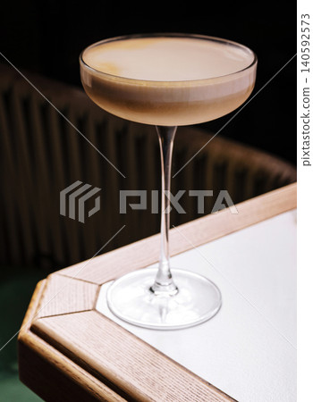 Espresso martini with foam in coupe glass on table 140592573