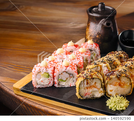 Japanese sushi rolls and fried tempura maki set on slate Japanese sushi rolls and fried tempura maki set on slate 140592590