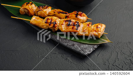 Japanese chicken yakitori skewers on leaf over dark stone 140592604