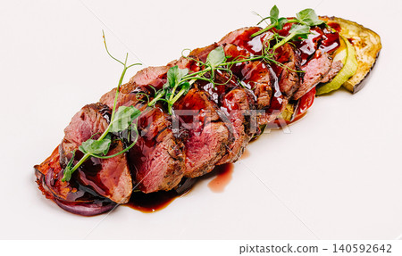 Grilled beef filet slices with roasted vegetables and sauce 140592642