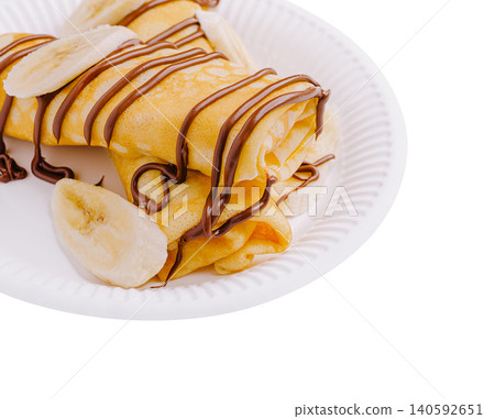Crepes with chocolate spread and banana slices on plate Crepes with chocolate spread and banana slices on plate 140592651