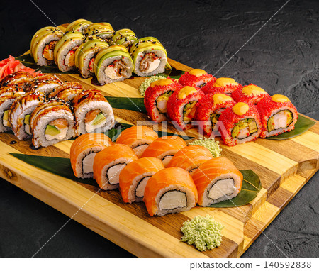 Assorted sushi rolls preparing for serving on wood board Assorted sushi rolls preparing for serving on wood board 140592838