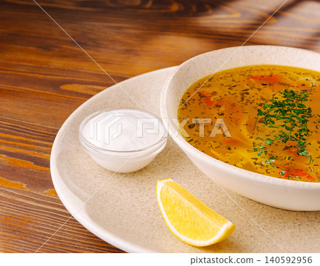 Chicken soup bowl with lemon and sour cream 140592956