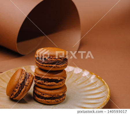 Brown macarons on a plate with a simple background in a kitchen setting Brown macarons on a plate with a simple background in a kitchen setting 140593017